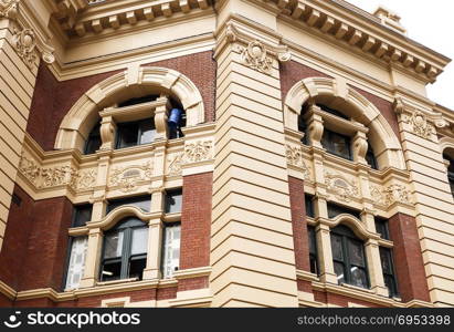 Detail of the windows and ionic order columns on the facade of the Flinders Street Railway Station in Melbourne, Victoria, Australia