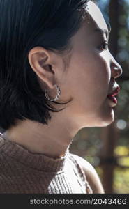 Detail of young woman wearing beautiful silver earring. Women accessories. Selective focus.