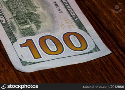 Detail on 100 dollars banknote. Close up of banknote laid out on table.