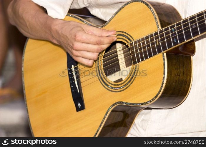 Detail photo of a man playing his guitar
