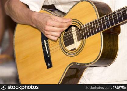 Detail photo of a man playing his guitar