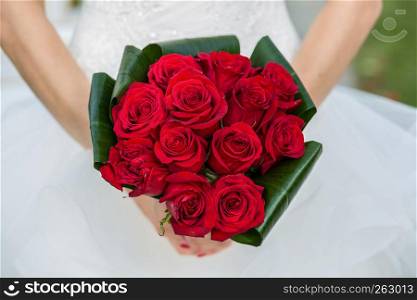 Detail shot of bride holding her rose bouquet at wedding