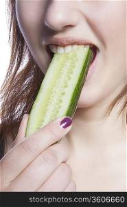 Detail shot of woman eating cucumber over white background
