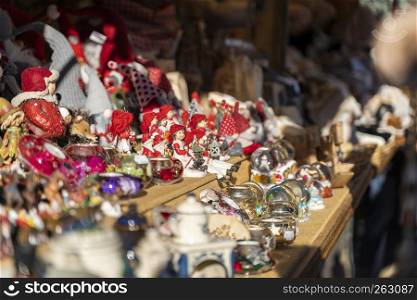 Detail shot with blur of various christmas decorations made out of porcelain and glass, christmas balls, angels, candele lights on the christmas market of merano in south tyrol in italy