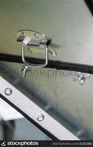 Detailed close up of black metal handle on steel wall background truck or car.. Close up of black plastic handle on metal