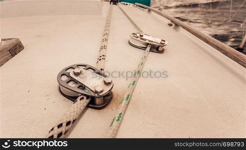 Detailed close up of rope block on white sail boat. Yachting objects concept.. Rope block on white sail boat