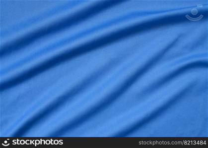 Detailed polyester blue fabric texture with many long folds. Detailed polyester blue fabric texture with many folds