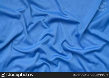 Detailed polyester blue fabric texture with many long folds. Detailed polyester blue fabric texture with many folds
