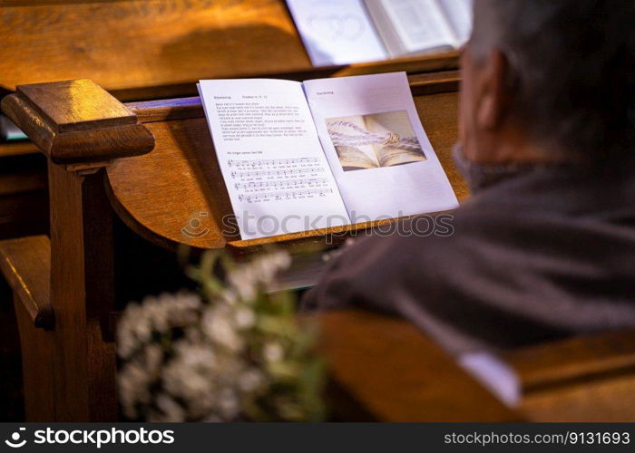 Details in an old medieval church with athjentic details during a mariage ceremony. Liturgy with biblical texts songs and psalms during a wedding service with wooden pews