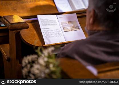 Details in an old medieval church with athjentic details during a mariage ceremony. Liturgy with biblical texts songs and psalms during a wedding service with wooden pews