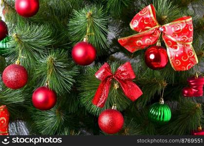 Details of a Christmas tree. Detail shot of Christmas tree branches hung with ribbons and Christmas toys. The concept of the traditional celebration of New Year and Christmas. World tradition. Christmas tree details