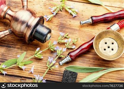 Details of a smoking shisha.Hookah on herbs. Hookah tobacco with sage flavor.. Smoked shisha with sage flavor.