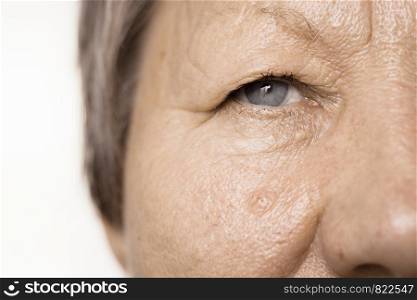 Details of senior woman half face. Elderly pensioner female, cheek and eye close up.. Elderly pensioner female half face portrait closeup