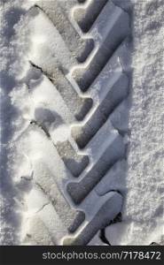 details of snow-covered road in the winter, traces of cars and tracks from transport, close-up on the roadway. details of snow-covered road