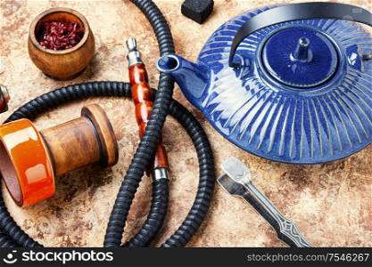 Details of tobacco hookah and teapot with tea.Eastern smoking shisha. Shisha hookah with teapot