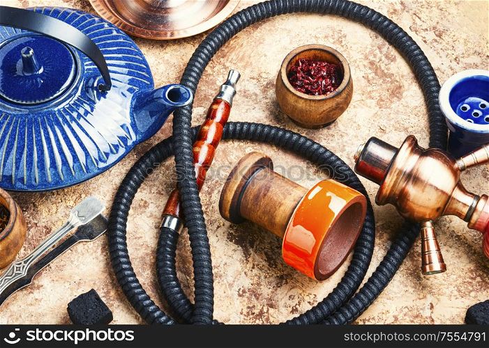 Details of tobacco hookah and teapot with tea.Egyptian smoking shisha and teakettle. Arabic shisha with teakettle