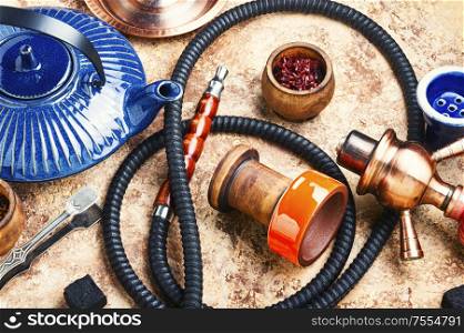 Details of tobacco hookah and teapot with tea.Egyptian smoking shisha and teakettle. Arabic shisha with teakettle