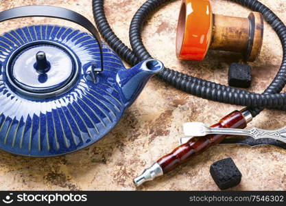 Details of tobacco hookah and teapot with tea.Egyptian smoking shisha. Shisha hookah with teapot