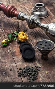 details Shisha and accessories on wooden background.image is tinted in vintage style