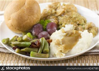 detali of vegetalble portion of a turkey dinner including mashed potatoes and cranberry accented green beans