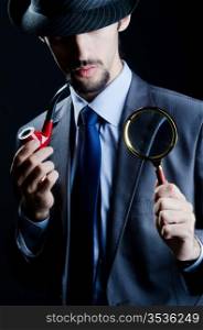 Detective with magnifying glass and pipe