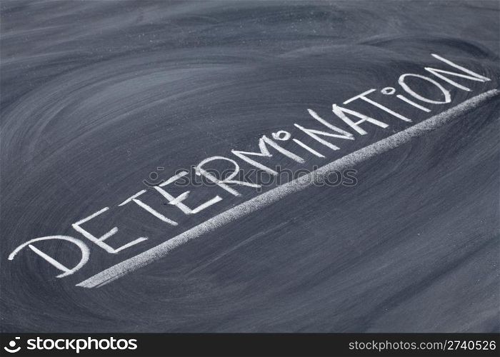 determination word in white chalk handwriting on blackboard