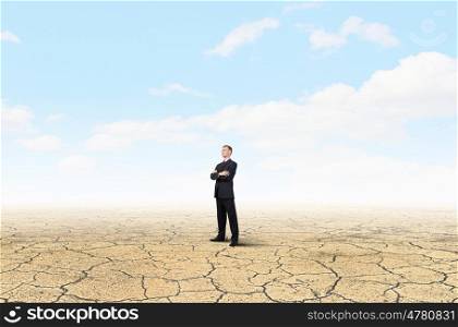 Determined in his business. Confident businessman with his arms crossed on chest in desert