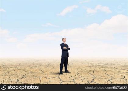 Determined in his business. Confident businessman with his arms crossed on chest in desert