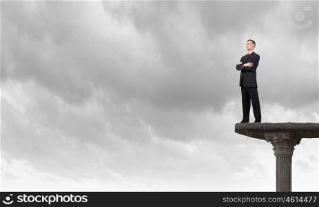 Determined in his business. Confident businessman with his arms crossed on chest standing on top