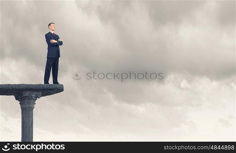 Determined in his business. Confident businessman with his arms crossed on chest standing on top