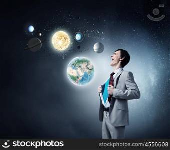 Determined super businessman . Young businessman acting like super hero and tearing his shirt off. Elements of this image are furnished by NASA