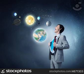 Determined super businessman . Young businessman acting like super hero and tearing his shirt off. Elements of this image are furnished by NASA