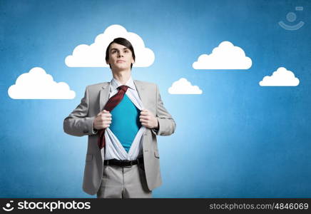 Determined super businessman . Young businessman acting like super hero and tearing his shirt off