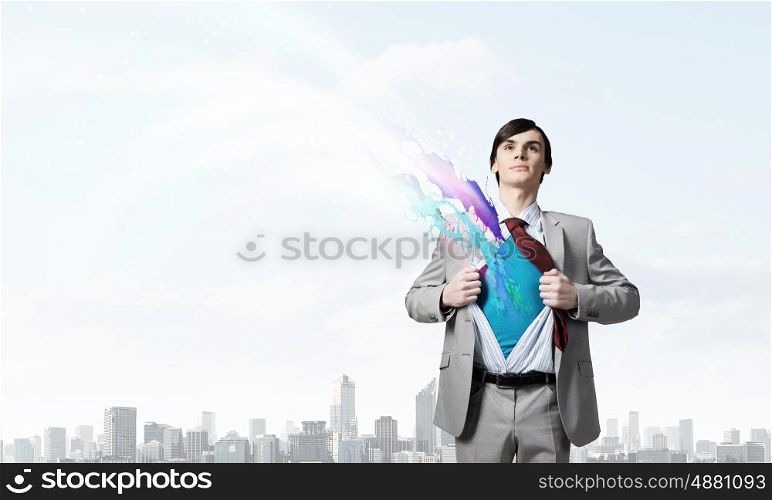 Determined super businessman . Young businessman acting like super hero and tearing his shirt off