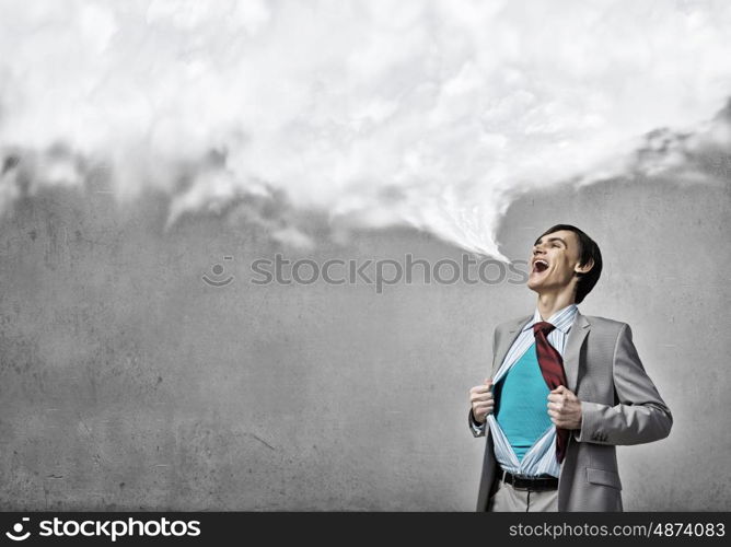 Determined super businessman . Young emotional businessman acting like super hero and tearing his shirt off