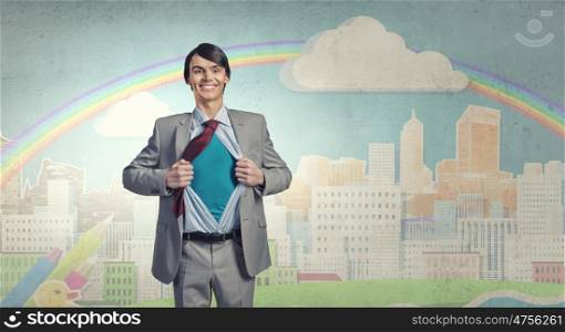 Determined super businessman . Young smiling businessman acting like super hero and tearing his shirt off