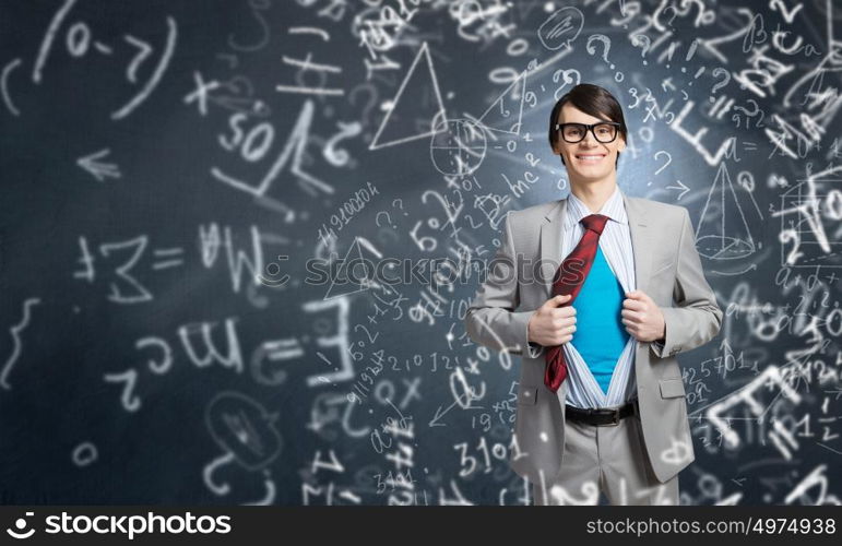 Determined super businessman . Young smiling businessman acting like super hero and tearing his shirt off