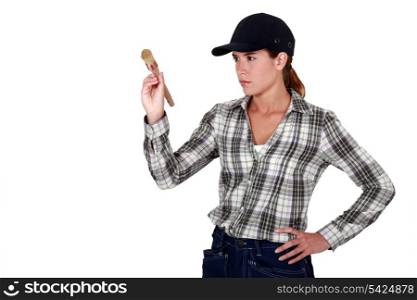 Determined woman holding up a paintbrush