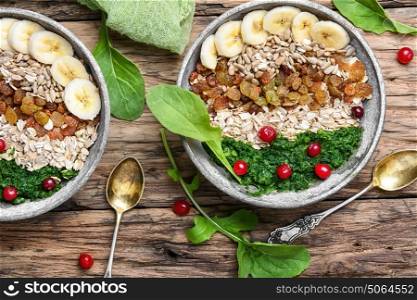 detox breakfast of oatmeal. concept of healthy diet of oatmeal,banana,raisins and spinach
