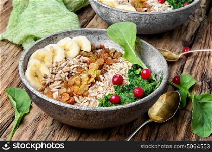 detox breakfast of oatmeal. concept of healthy diet of oatmeal,banana,raisins and spinach