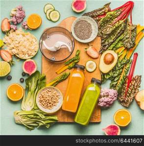Detox drinks smoothie making concept. Various healthy fresh fruits, vegetables, seeds, nuts, kale and chard leaves with bottles and mixer on light mint table background with cutting board, top view