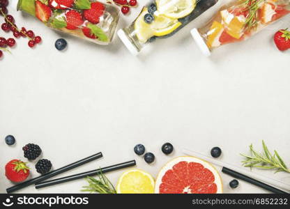 Detox fruit infused flavored water. Refreshing summer homemade cocktail on grey background. Top view