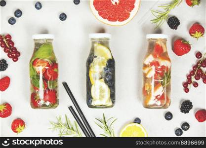 Detox fruit infused flavored water. Refreshing summer homemade cocktail on grey background. Top view
