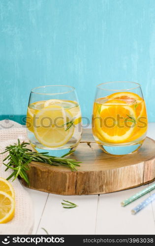 Detox fruit infused flavored water. Refreshing summer homemade cocktail with orange, lemon and rosemary leaves