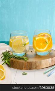 Detox fruit infused flavored water. Refreshing summer homemade cocktail with orange, lemon and rosemary leaves