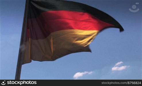 Deutschlandflagge weht im Wind in leuchtenden Farben vor blauem Himmel