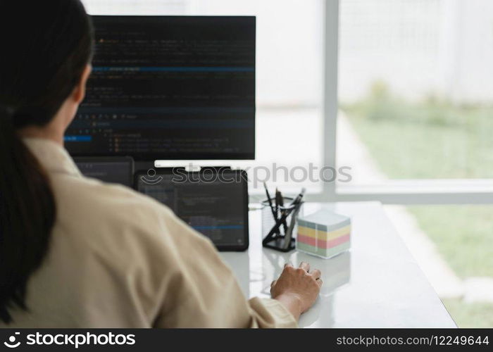 Developer programmer checking code on multiple monitor while programming to developing web and apps.
