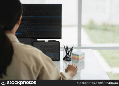Developer programmer checking code on multiple monitor while programming to developing web and apps.