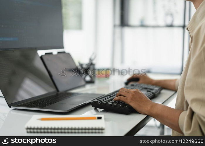 Developer programmer checking code on multiple monitor while programming to developing web and apps.