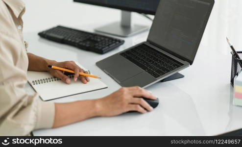 Developer programmer use mouse and checking code on laptop while programming to developing website.
